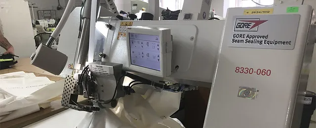 Seam sealing equipment for taped waterproof outerwear construction
